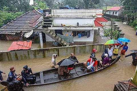 Rescue officials assist villagers out of a flooded area near Kochi.(PTI)