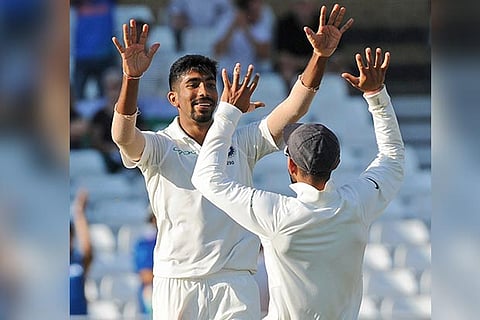 Skipper Virat Kohli, right, congratulates teammate Jasprit Bumrah, left