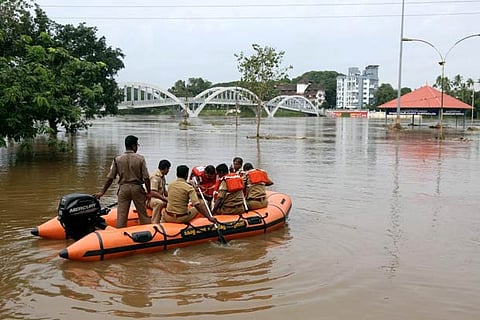 Rescue personnel patrol the flooded waters on the banks of Periyar River