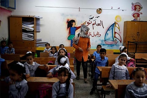 Palestinian schoolchildren sit inside a classroom at an UNRWA-run school