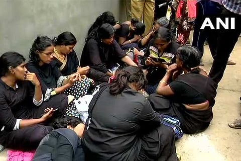 Lord Ayyappa devotees hold a protest before the group of women devotees who are gathered at Pampa.