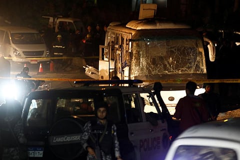Police officers inspect a scene of a bus blast in Giza, Egypt