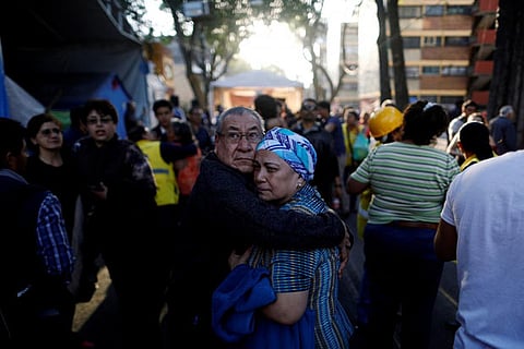 People react after an earthquake shook buildings in Mexico City