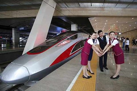 Railway workers pose for photos with the Fuxing