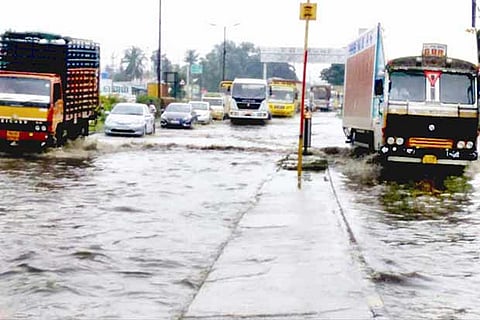 Vehicles wade through the flooded Kondalampatty bypass road in Salem district on Monday