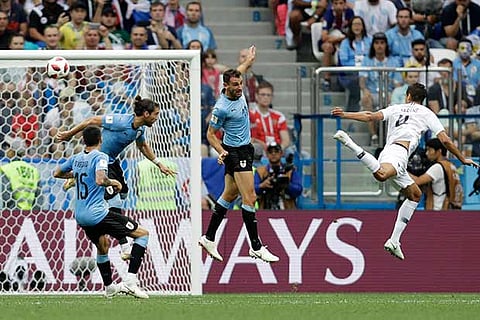 France?s Raphael Varane (far right) heads the opening goal against Uruguay