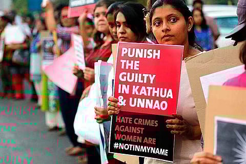 File photo of a girl holding a placard during a protest against the Kathua rape case