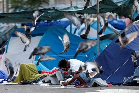 A migrant washes his face in a camp set by the Baobab aid group in Rome