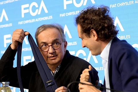 Fiat Chrysler Automobiles CEO Sergio Marchionne jokes with a tie next to chairman John Elkann
