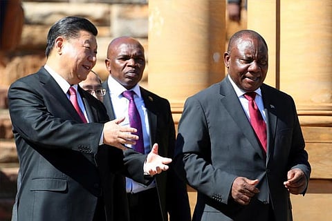 China's President Xi Jinping walks with South African President Cyril Ramaphosa