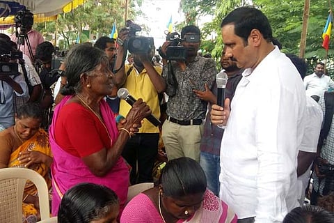 PMK leader Anbumani Ramadoss interacting with a villager during the public hearing in Salem district