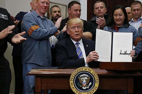 US President Trump holds up a proclamation to establish tariffs