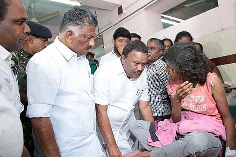 Tamil Nadu deputy CM K Panneerselvam visits a Theni fire victim at a hospital