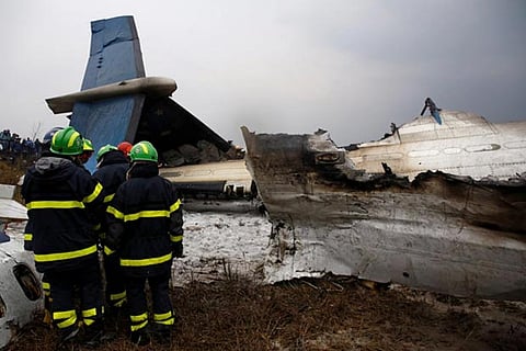 Rescue workers work at the wreckage of a US-Bangla airplane after it crashed