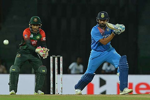 Rohit Sharma (R) is watched by Bangladesh wicketkeeper Mushfiqur Rahim as he plays a shot