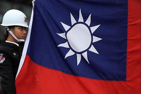 A military honour guard holds a Taiwanese national flag