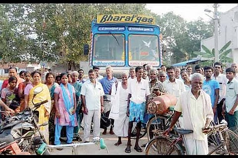 Protestors with the detained lorry in Agrapalayam on Friday