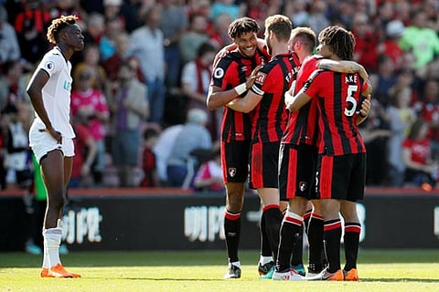 Bournemouth's Tyrone Mings and teammates celebrate as Swansea City's Tammy Abraham looks dejected