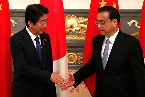 Chinese Premier Li Keqiang shakes hands with Japan's PM Shinzo Abe