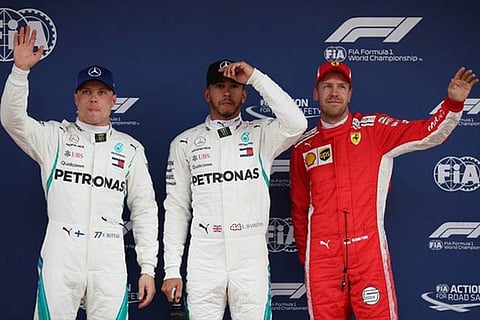 Mercedes driver Hamilton (C) along side his teammate Bottas (L) and Ferrari's Vettel