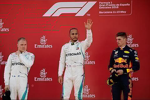 Mercedes' British driver and first place winner Lewis Hamilton (C) celebrates on the podium