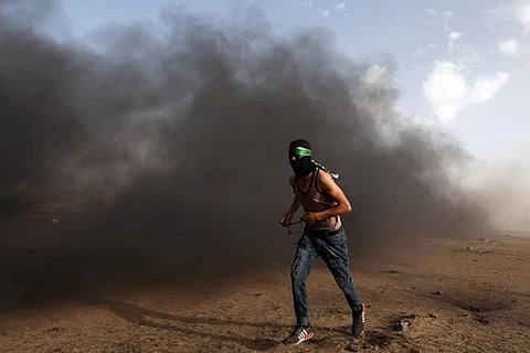 A demonstrator runs during a protest where Palestinians demand the right to return to their homeland