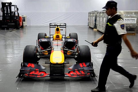 A security guard walks past Red Bull team's Formula One car during an event in Hanoi, Vietnam