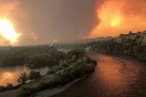 Smoke and flames are seen as a wildfire spreads through Redding, California
