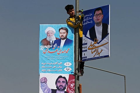 A man installs election posters during the first day of election campaign in Kabul, Afghanistan