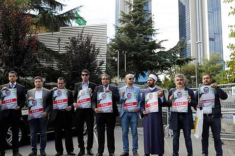 Demonstrators holds pictures of Saudi journalist Jamal Khashoggi at a protest