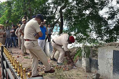 Security personnel inspect the site of a low-intensity bomb blast at Panbazar in Guwahati