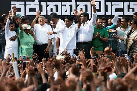 Sri Lanka's sacked PM Ranil Wickremesinghe waves to his supporters during a protest rally