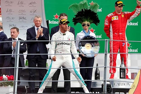 Lewis Hamilton celebrates on the podium after winning the race alongside Kimi Raikkonen