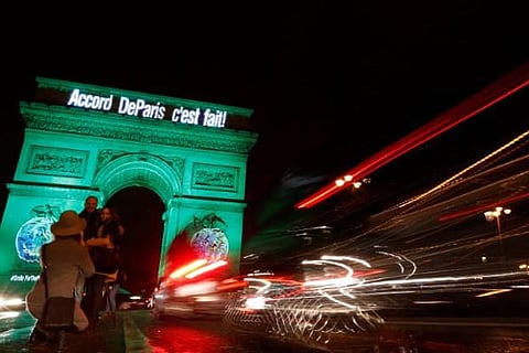 File photo of the Arc de Triomphe is illuminated in green with the words "Paris Agreement is Done"