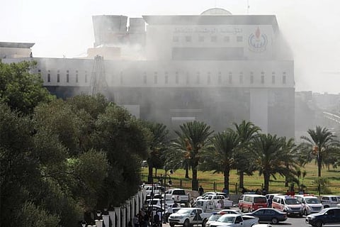 Smoke rises from headquarters of Libya's National Oil Corporation after 3 masked persons attacked it