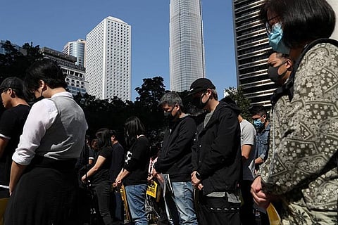 Anti-government demonstrators stand still during a moment of silence, photo courtesy Reuters