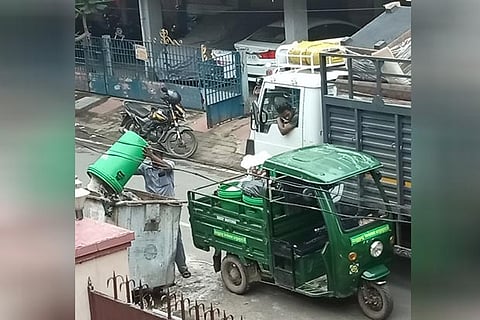 A conservancy worker dumping the garbage into street bin