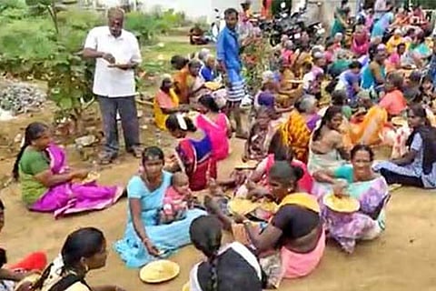 People have biriyani at a godown near Sivan temple at Chettinayaknapatti village in Dindigul on Wednesday