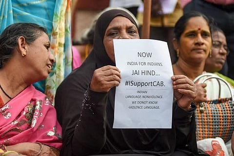 A woman holds a placard declaring her support for Citizenship Act, during a rally by BJP in Chennai