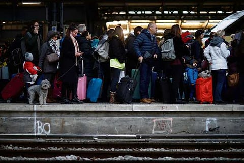 Commuters walk on a platform at Gare de l'Est train station during a strike by all unions