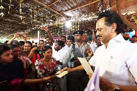 DMK chief MK Stalin accepts a petition from a youth during a public meeting near Andipatti on Saturday