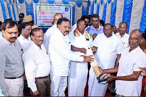 Puducherry Chief Minister V Narayanasamy hands over an assistive device to a beneficiary on Monday