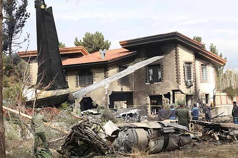 The site of a plane crash is seen in Alborz Province, Iran