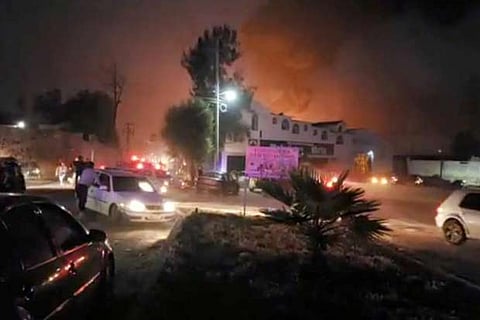 People react at the scene where a ruptured fuel pipeline exploded