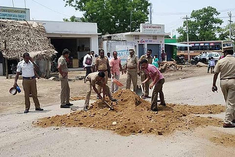 Police personnel manually filling potholes on busy roads in Tirupattur