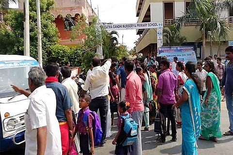 Parents gather to protest the management?s decision, in front of the school on Monday