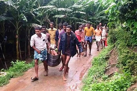 Villagers carry one of the victims in a cloth cradle to the hospital as vehicles could not reach the spot
