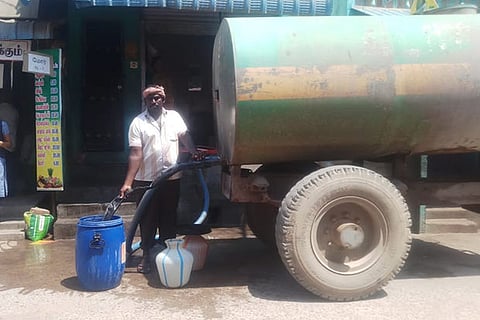 People collect water from a private tanker in Pernambut