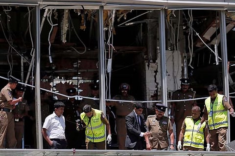 Crime-scene officials inspect the explosion area at the Shangri-La Hotel in Colombo