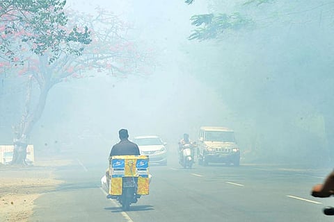 Thick smoke from the burning garbage affects motorists on the Valparai Road on Monday